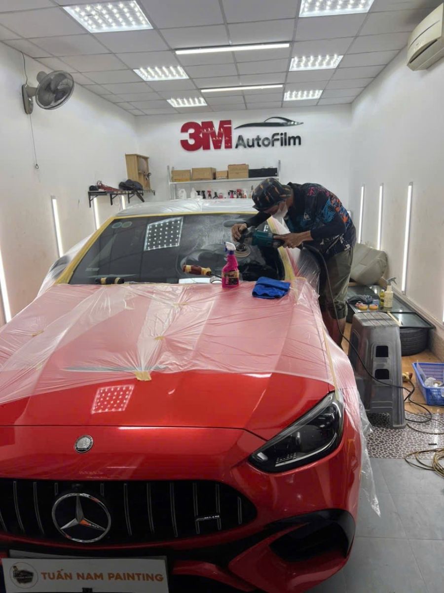 Kỹ thuật viên đang đánh bóng kính lái xe ô tô